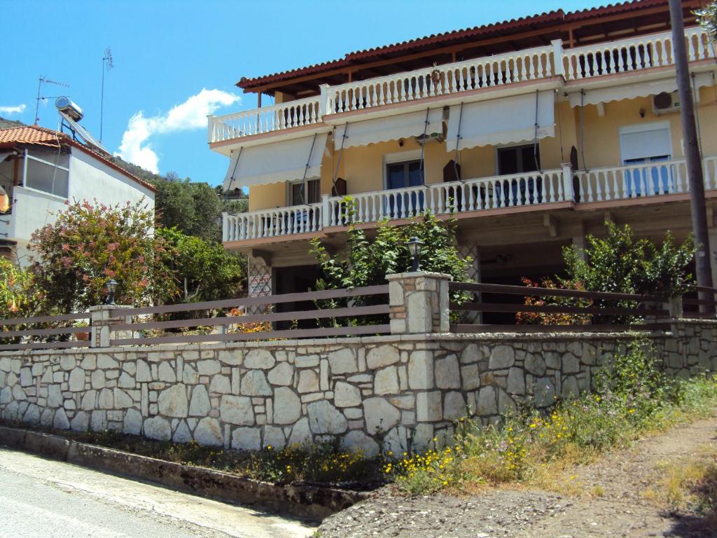 a house with a stone wall next to a street at Stamatia Rooms in Parga