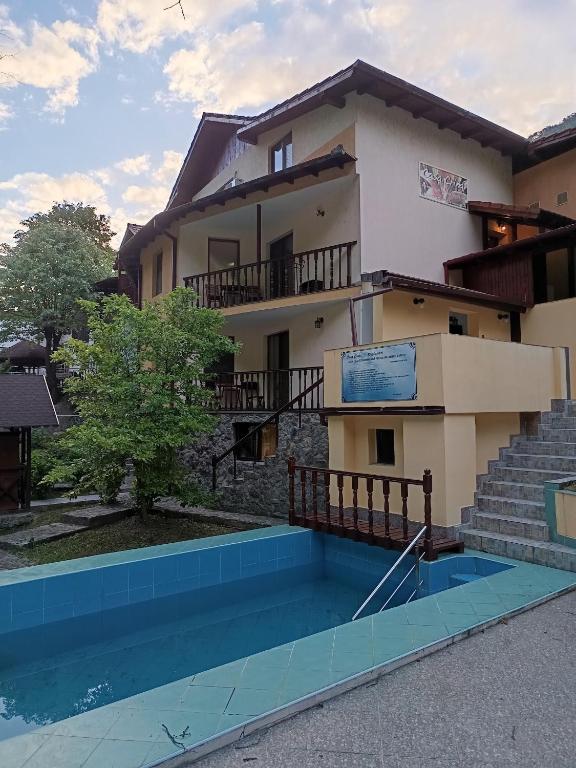 a house with a swimming pool in front of it at Casa Crina in Băile Herculane