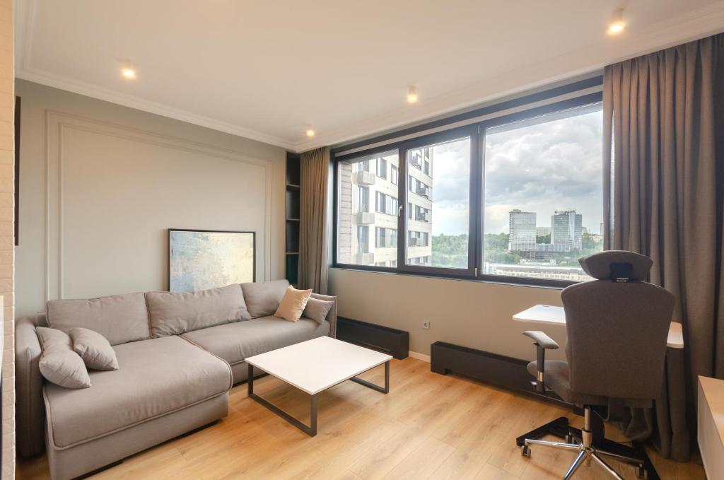キーウにあるPetrovdom Apartments 17-183B in RC New York Concept House, 74 Antonovycha Streetのリビングルーム(ソファ、デスク、窓付)