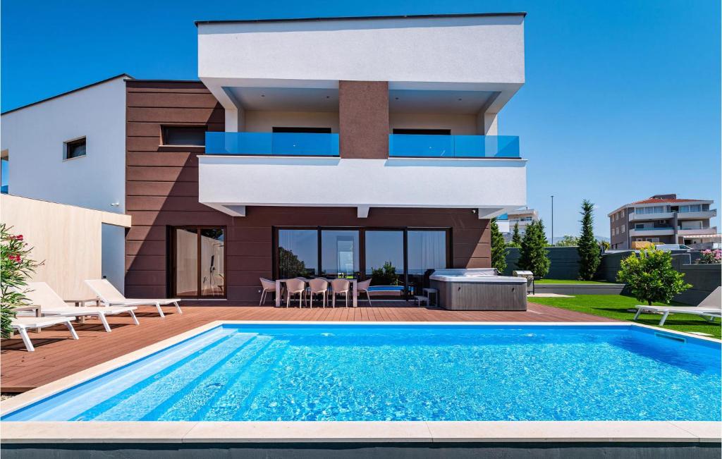 a house with a swimming pool in front of a house at Beautiful Home In Novalja in Novalja