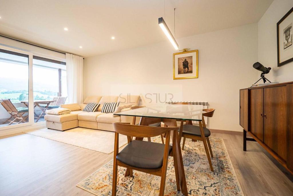 a living room with a table and a couch at Avalón I By Silastur in Villaviciosa