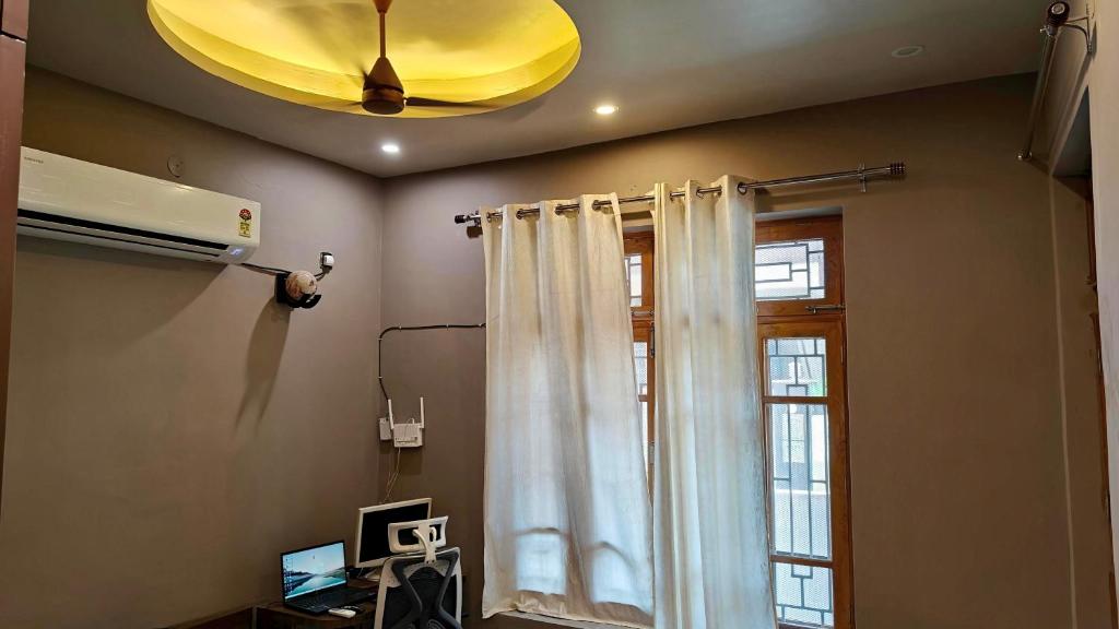 a room with a white curtain and a window at Navigator's Nook in Dehradun