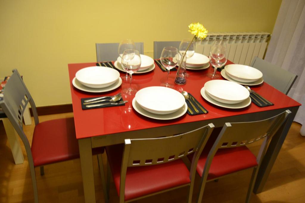 a red table with plates and wine glasses on it at Apartamento Turistico Dct. Creus in Guadalajara