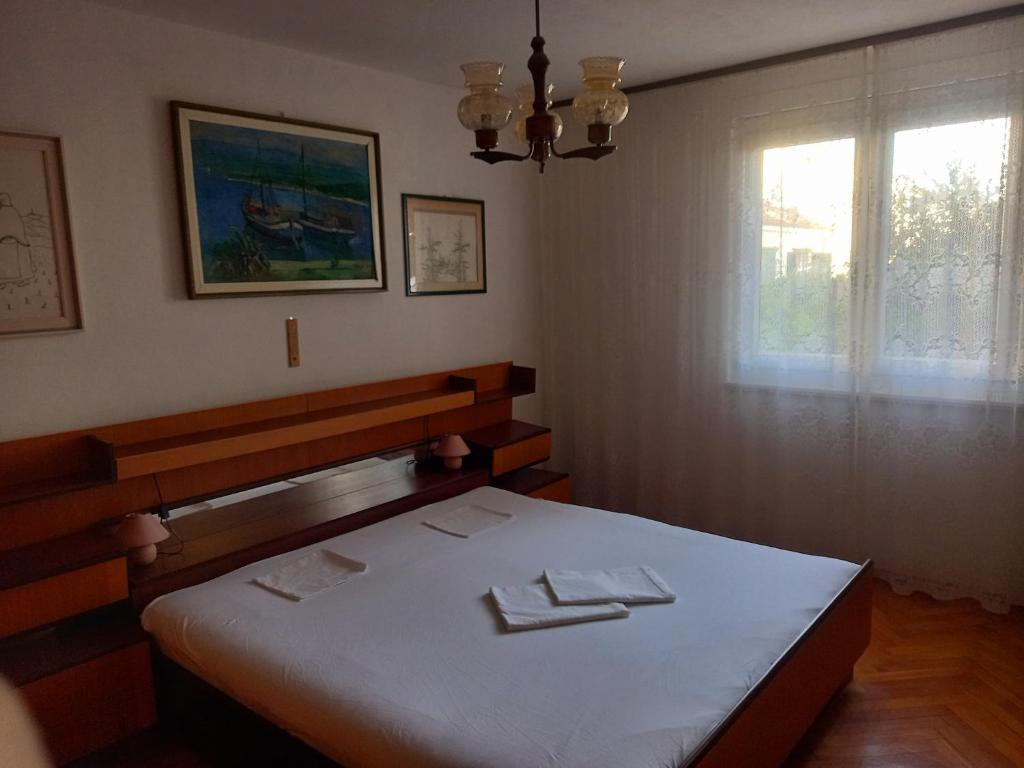 a bedroom with a white bed with a window at Largo in Crikvenica