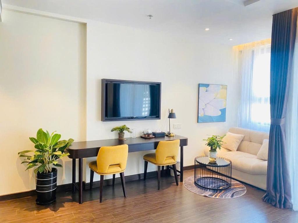 un salon avec une table, des chaises et un canapé dans l'établissement The Sapphire residence, à Hạ Long