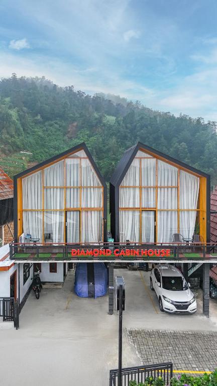 two buildings with a car parked in a parking lot at Diamond Cabin House in Diyeng