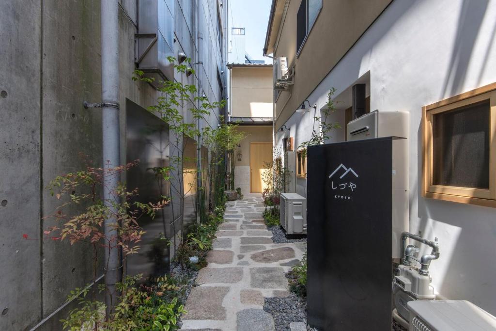 um beco estreito com um edifício e uma placa nele em Shizuya KYOTO em Quioto