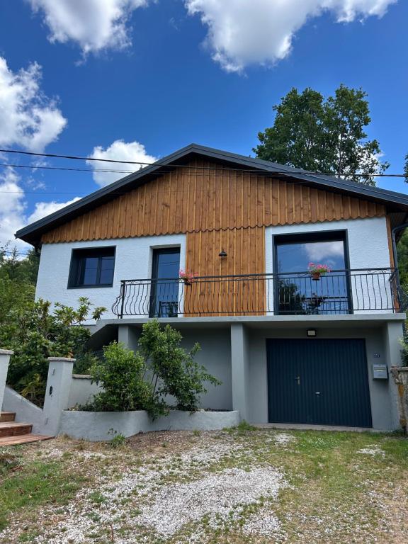 a house with a porch and a balcony at Refuge nature de Aumontzey in Granges-Aumontzey