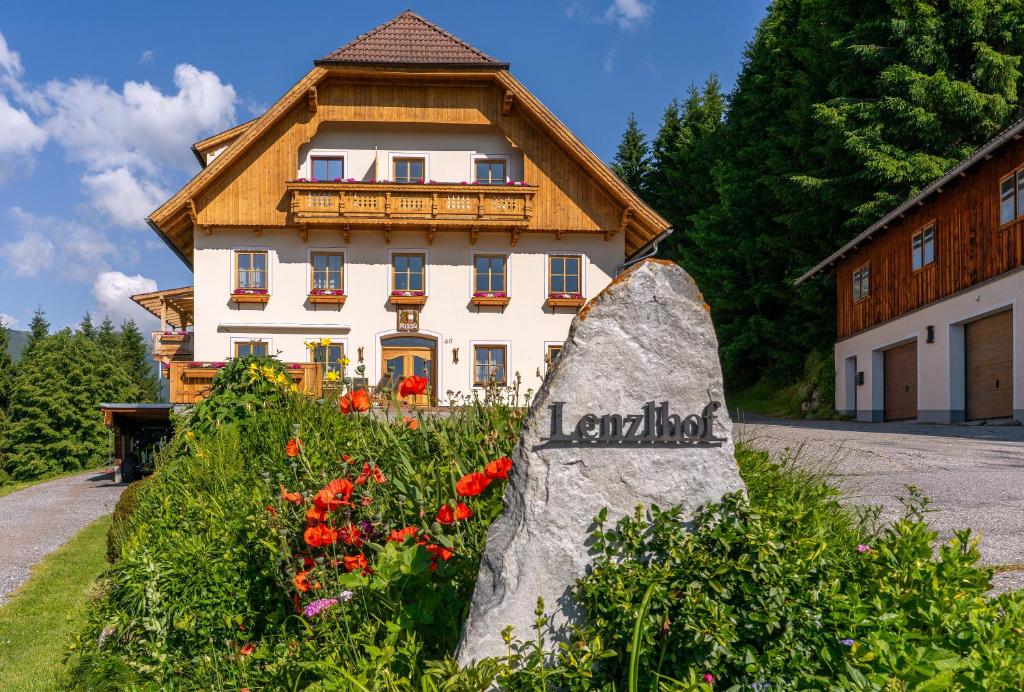 a building with a sign in front of a garden at Lenzlhof in Mariapfarr
