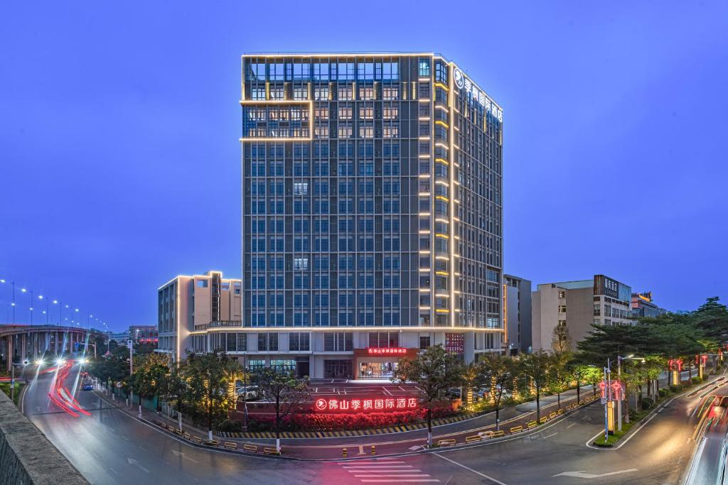 Un palazzo alto nel cuore di una città di notte di Foshan Jifeng International Hotel a Foshan