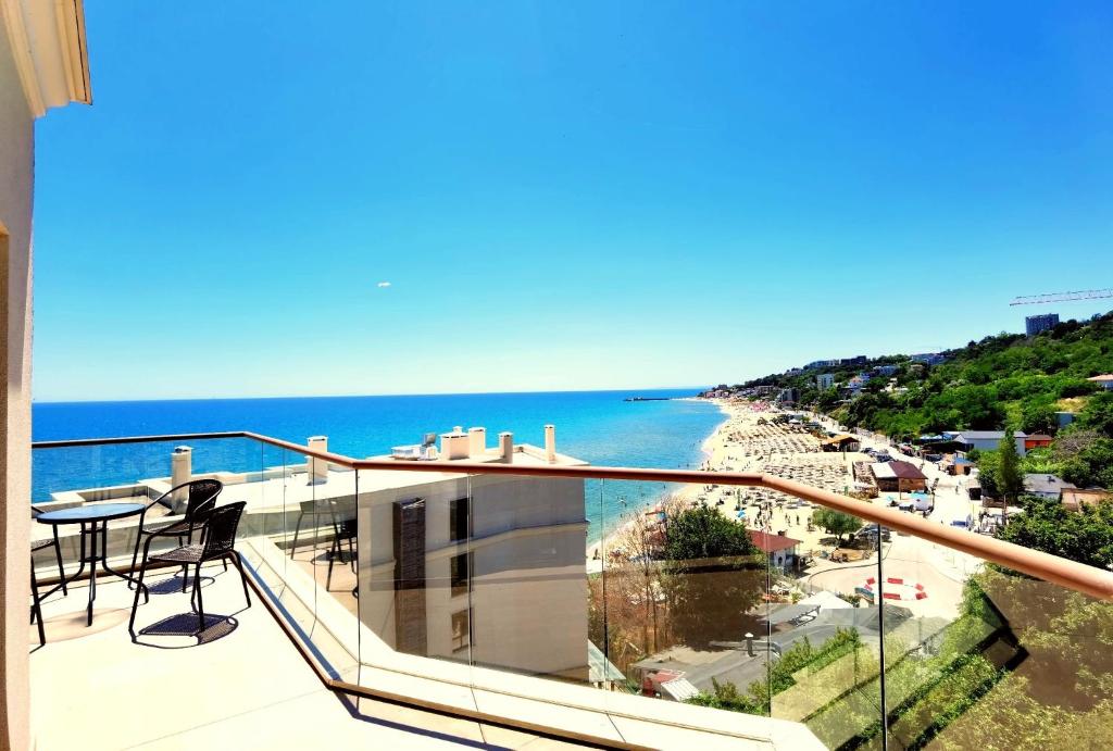 a balcony with a view of a beach and the ocean at Cabacum Pleasure Beachfront Apartments in Varna City