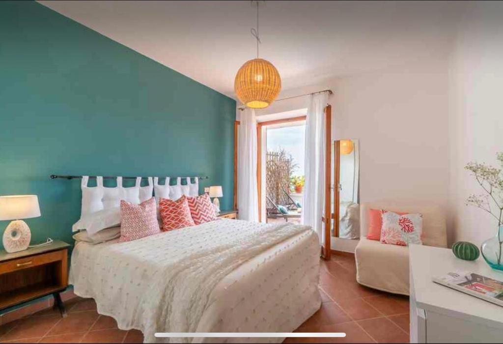 a bedroom with a large bed and a blue wall at Belvedere apartment in Castiglione della Pescaia