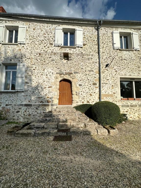 a brick building with a wooden door on it at Loft Préaux in Villeneuve-sur-Fère