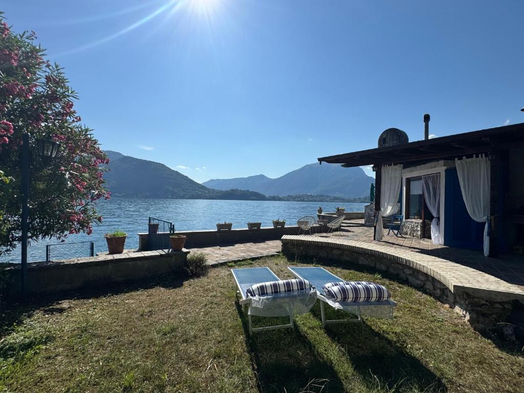 two chairs sitting on the grass near the water at Villa Planca by Gottschalk in Fiumelatte