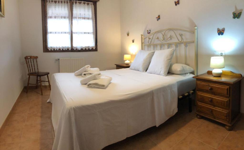a bedroom with a large white bed with towels on it at Playa Ribadesella Cris in Ribadesella