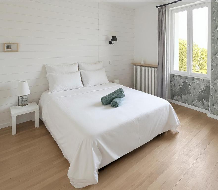 a bedroom with a white bed with a teddy bear on it at Maison cosy with private garden, 4 bedrooms, Wine Route in Nuits-Saint-Georges