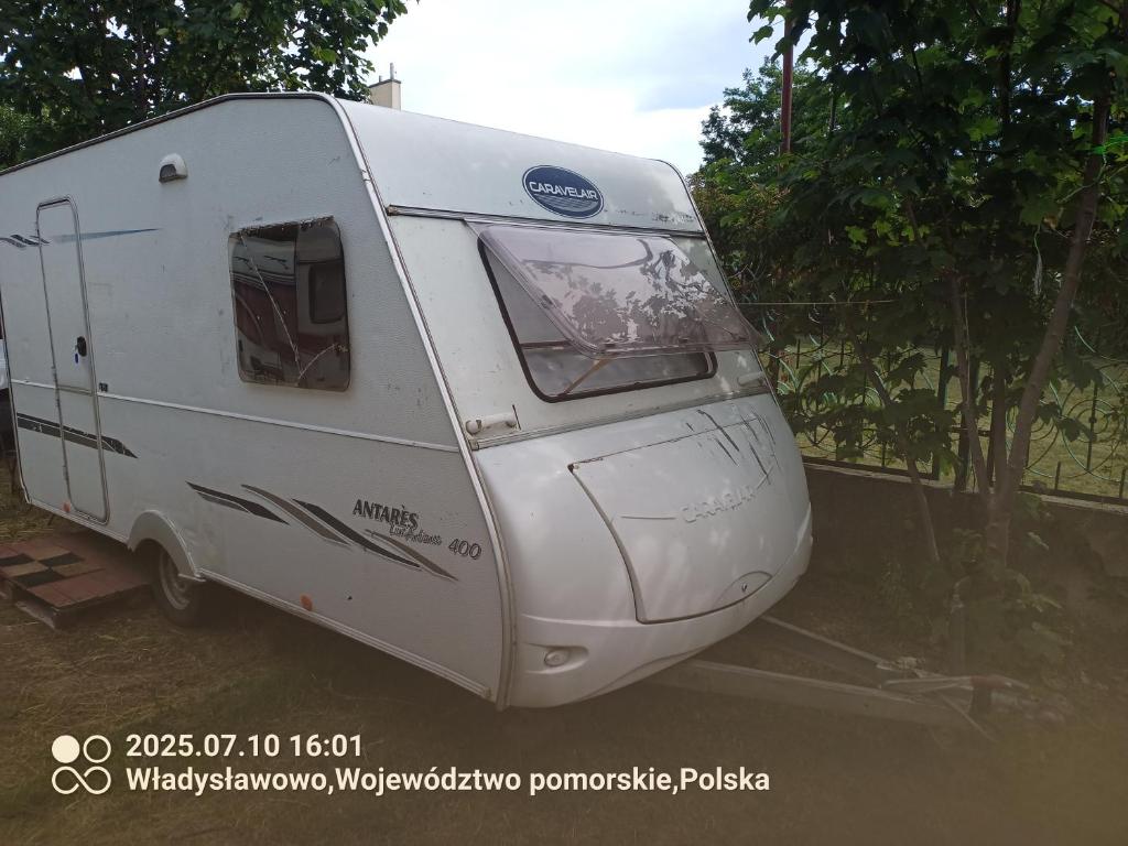 a white trailer parked next to a fence at Zielony Port numer 2 in Władysławowo