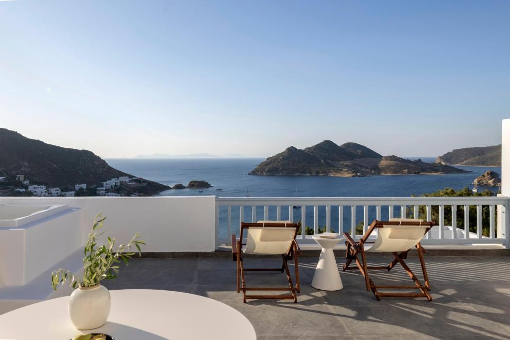 un patio con sillas, una mesa y el océano en Panorama Serenity Suites, en Patmos