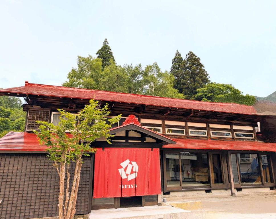 a building with a red sign on the side of it at 源泉掛け流し温泉Villa The ITAYA in Yuzawa