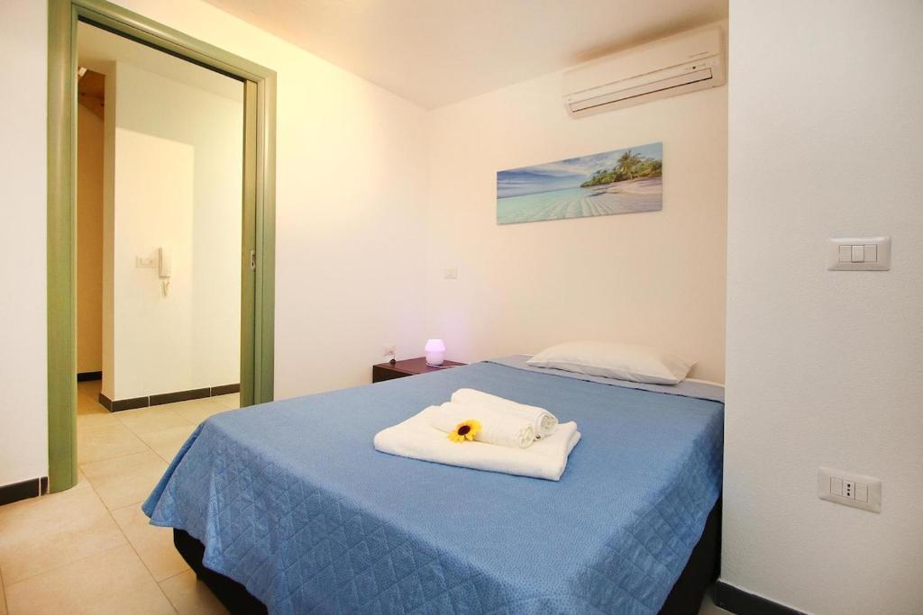 トッレ・グランデにあるOhana Beachのベッドルーム1室(タオル付きの青いベッド1台付)