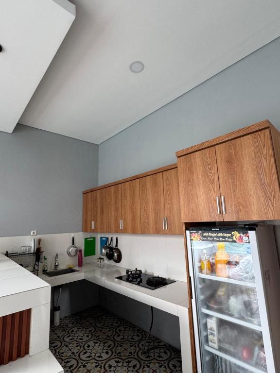 a kitchen with wooden cabinets and a refrigerator at Belong guest house in Mantaak