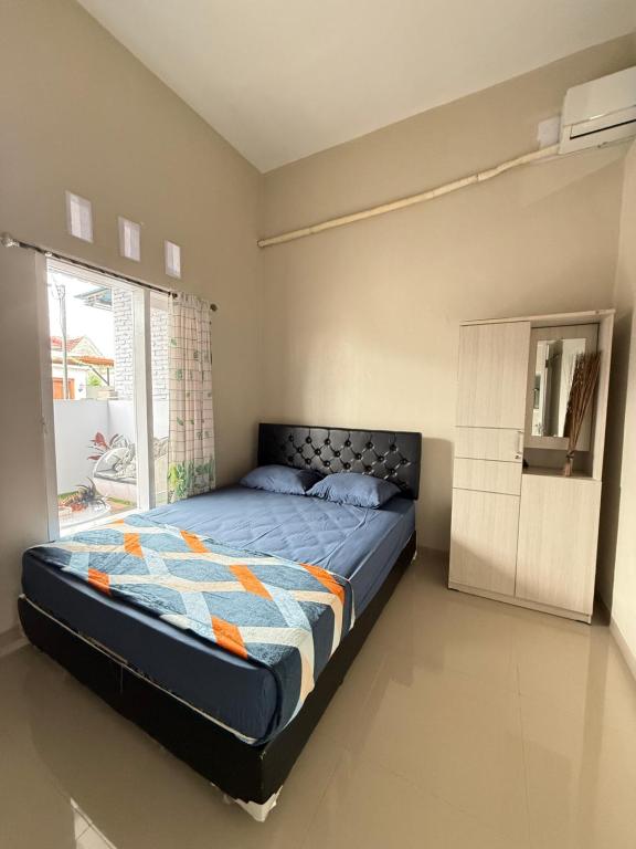 Ένα ή περισσότερα κρεβάτια σε δωμάτιο στο Grey House Banyuwangi, Rest Easy,Stay Cozy