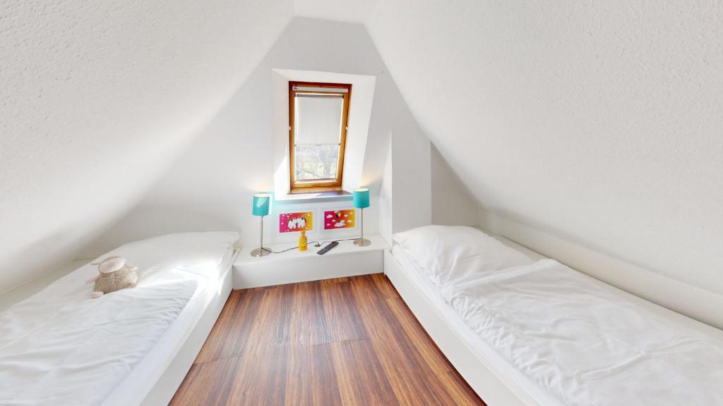 two beds in a small room with a window at Gorch Fock - 11 in Cuxhaven