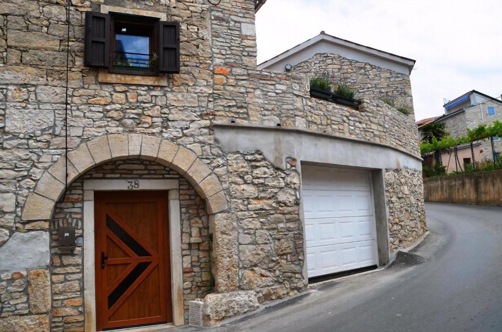un edificio in pietra con garage e porta in legno di Filira Medulin a Medulin
