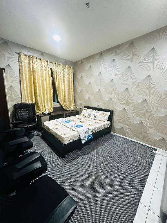 a bedroom with a bed and a chair in it at Elite Shine Holiday Home in Sabkhah