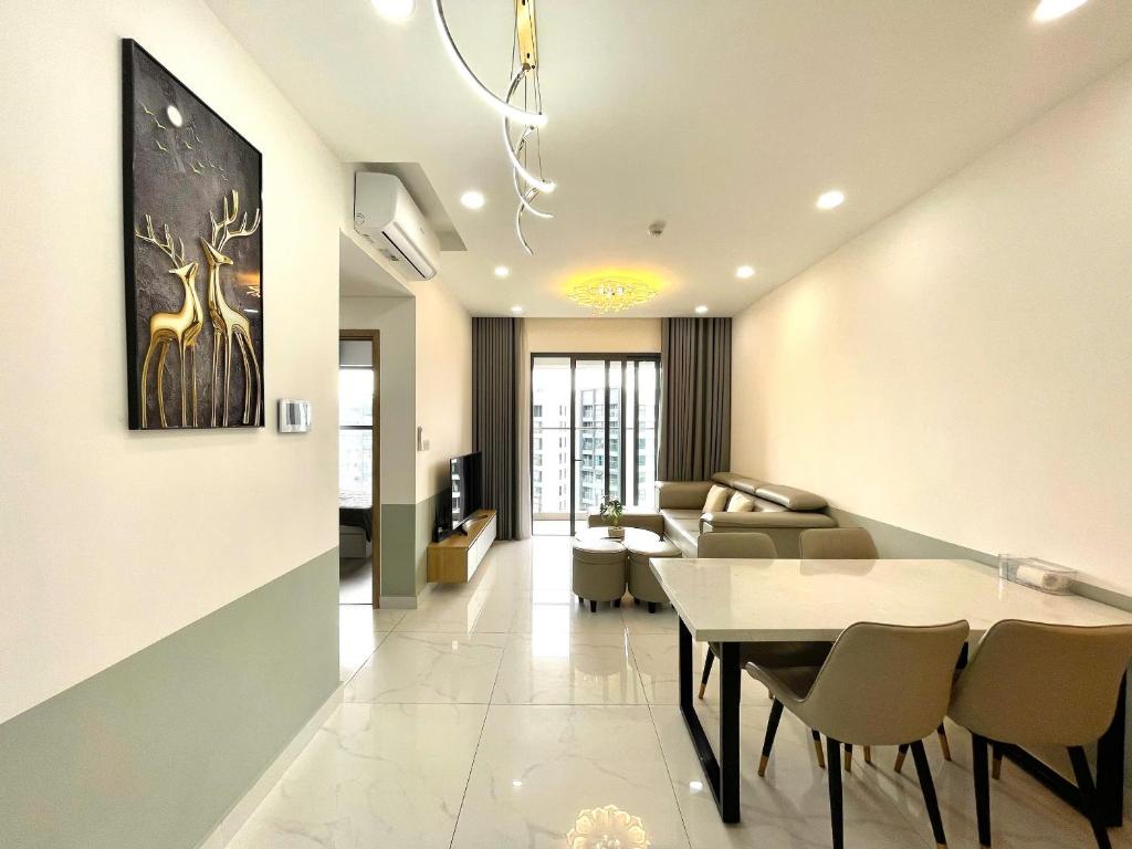 a dining room and living room with a table and chairs at Apartment Alnata Diamond 2 Bedrooms Celadon City in Kon Rung (1)