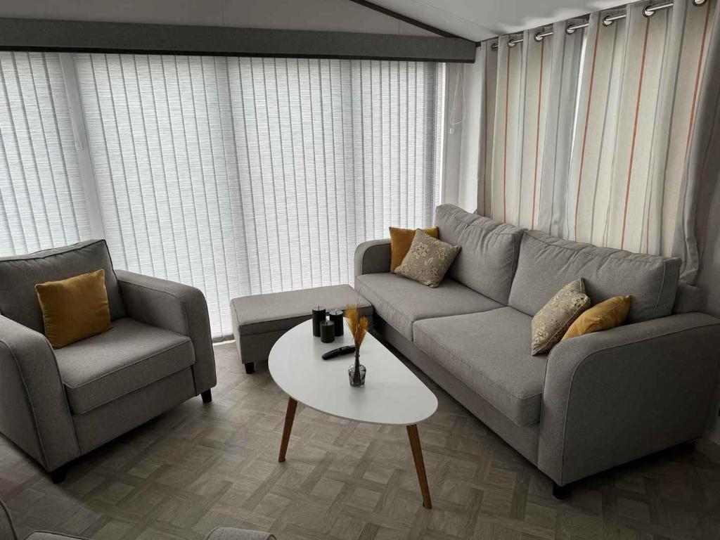 a living room with a couch and two chairs and a table at Vakantiepark Klein Strand - Luxe Chalet 4p in Jabbeke