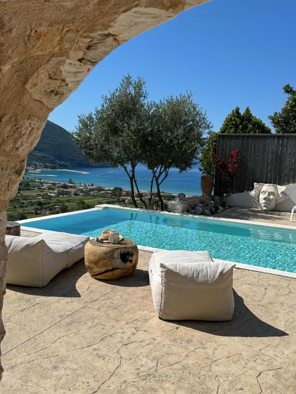 a pool with two beds and a view of the water at Villa Surf Ponti in Póndi
