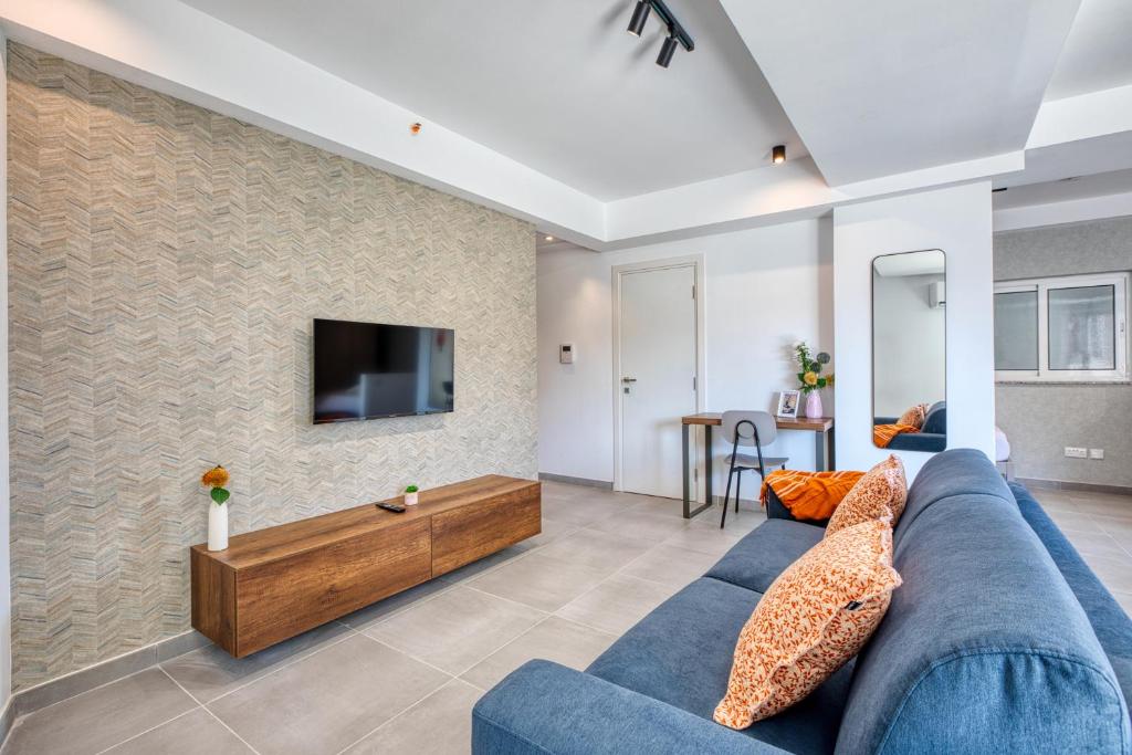 a living room with a blue couch and a tv at Stunning apartment Heart of St Julians Sleeps 5 in San Pawl il Bahar