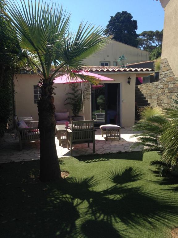 un patio avec deux bancs et un palmier dans l'établissement Les Jardins De Galicia, à Sète
