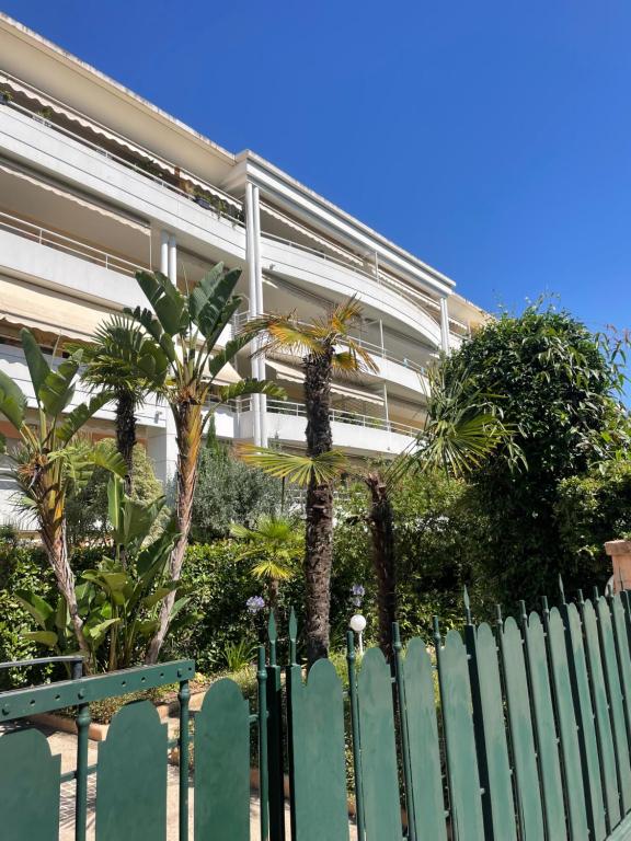 a fence in front of a building with palm trees at Prince de Galles in Cannes