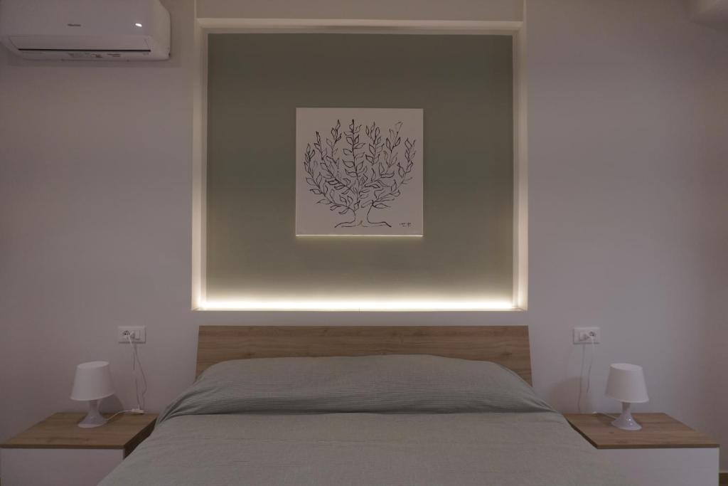 巴勒莫Le Stanze del Massimo的卧室里有一张床，墙上挂着一幅画