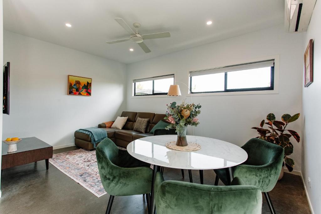 BooragulにあるBright & Modern Booragul Home for Familiesのリビングルーム(テーブル、緑の椅子付)