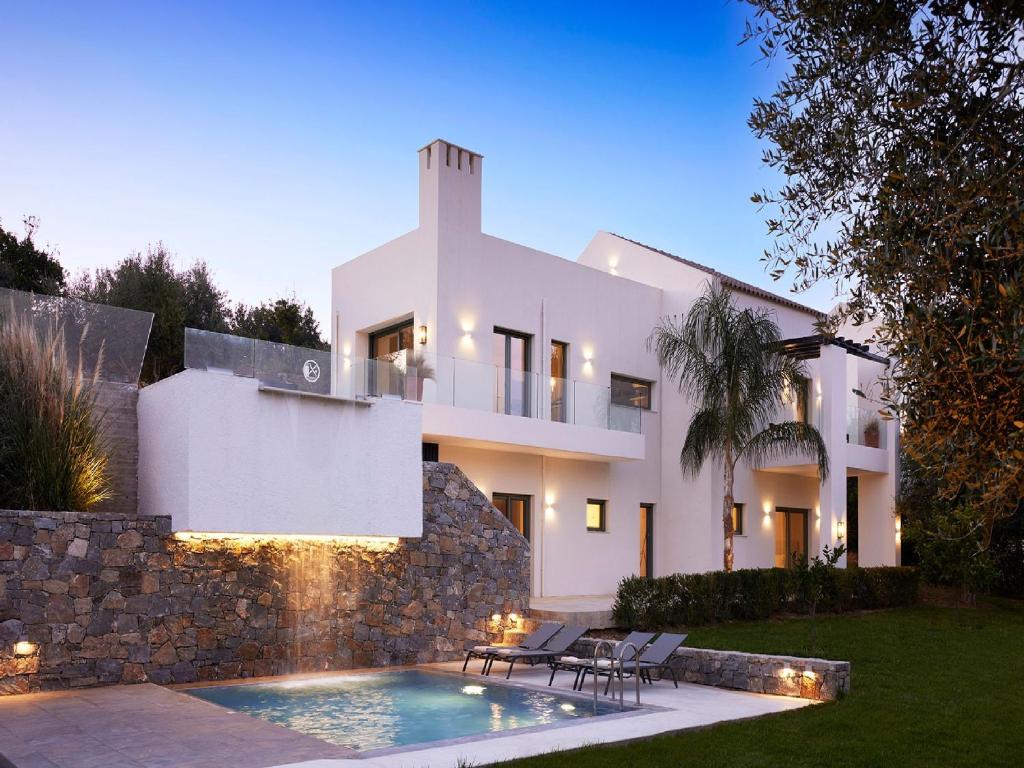 a white house with a swimming pool in front of it at Magnificent Crete Villa 4 Bedrooms Villa Ánthos Two Large Private Pools & Jacuzzi Bbq Close To The Beach Rethymno in Prínos