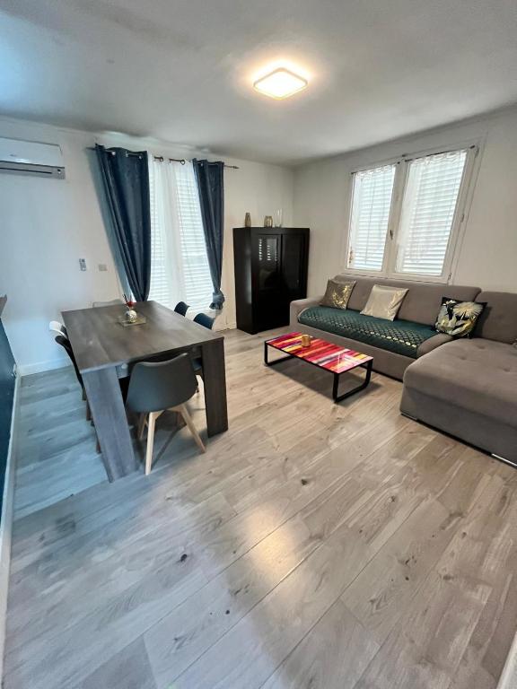 un salon avec un canapé et une table dans l'établissement Pavillons 6 personnes 15 minutes Disney, à Lagny-sur-Marne