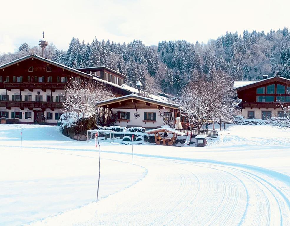 a snow covered road in front of a lodge at Almliesl JOTI-687 in Sankt Johann in Tirol