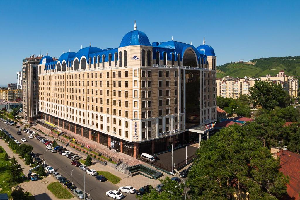 un grand bâtiment avec un dôme bleu en haut dans l'établissement Shera Inn Hotel, à Almaty