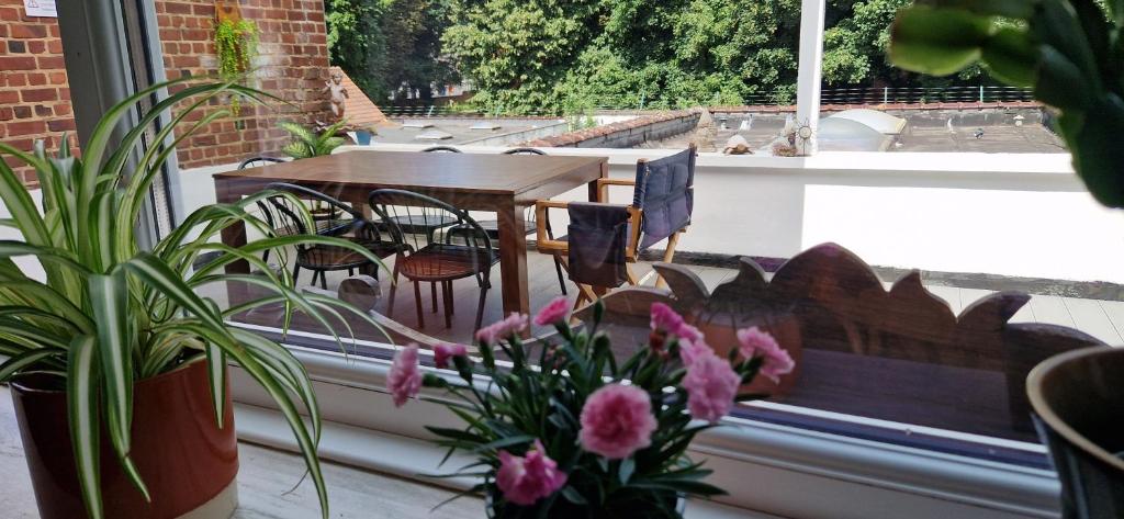 a balcony with a table and chairs and flowers at Apartamento de la grotte in Brussels