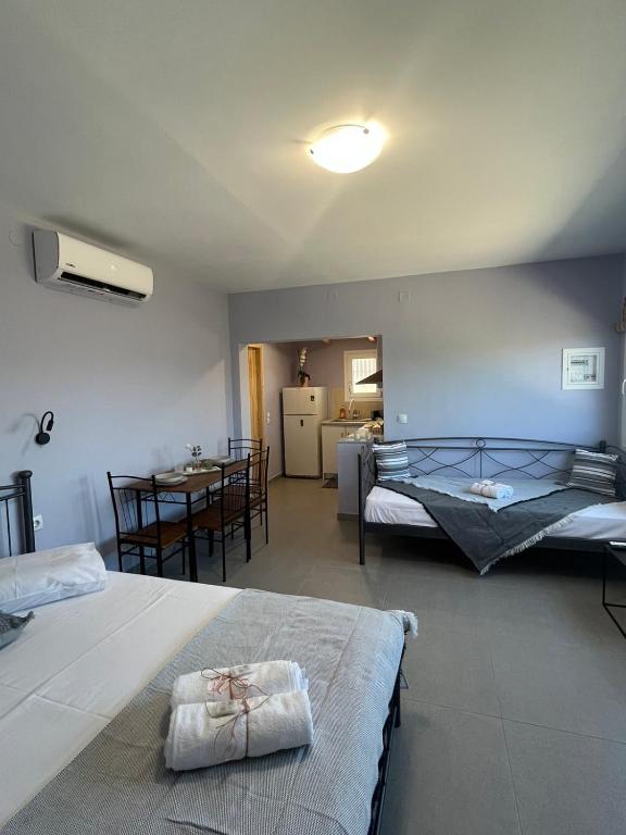a bedroom with two beds and a table and a kitchen at Nick House Nikiana in Nikiana