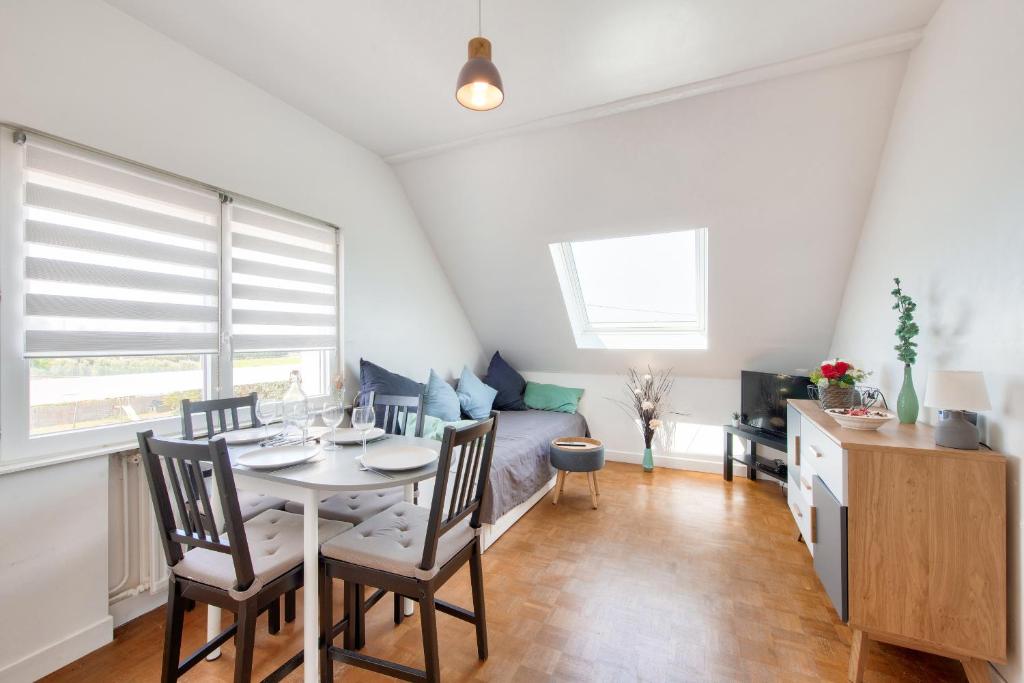 a living room with a table and chairs and a couch at Vue mer - 100m de la plage - 4 adultes 1 enfants in Plounéour-Trez