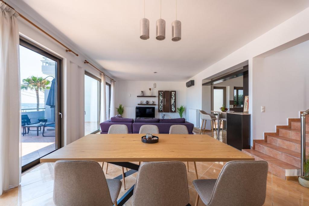 a living room with a wooden table and chairs at Kalamaki Del Mar in Chania