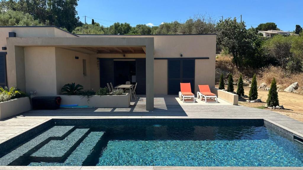 une maison avec une piscine devant une maison dans l'établissement Un air de paradis à Corbara, à Corbara