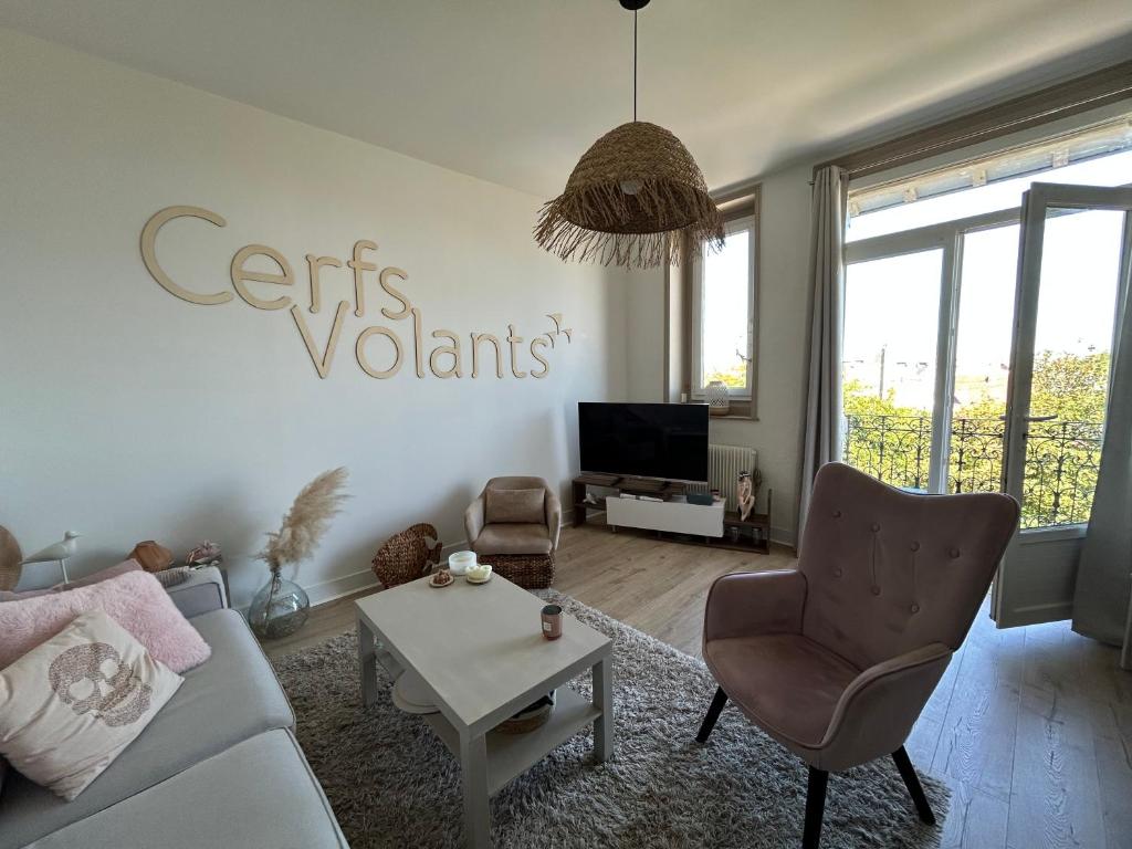 ein Wohnzimmer mit Sofa, Sesseln und Fernseher in der Unterkunft Appt lumineux - 2 chambres - Mer et commerces in Berck-sur-Mer