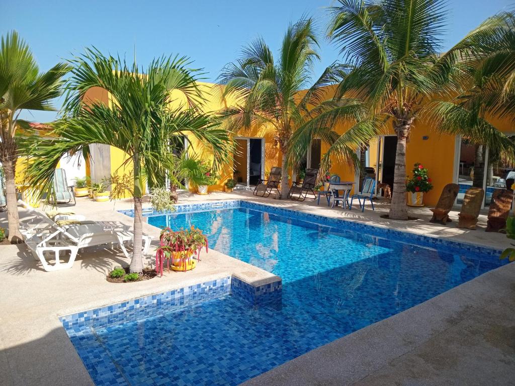 een zwembad met palmbomen in een resort bij Hôtel Colibri Lac Rose in Niaga