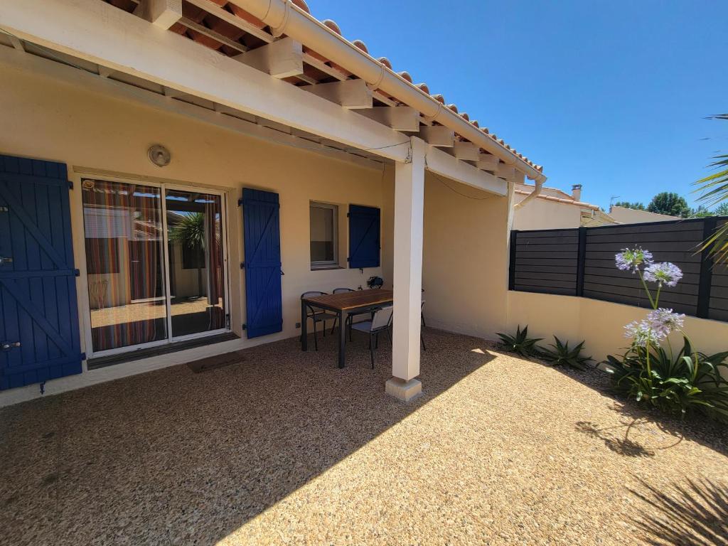 une terrasse d'une maison avec une table sur celle-ci dans l'établissement Villa 5 couchages 2 chambres belle terrasse d'angle piscine commune dans résidence sécurisée à 200m de la mer LRMA2A, à Portiragnes