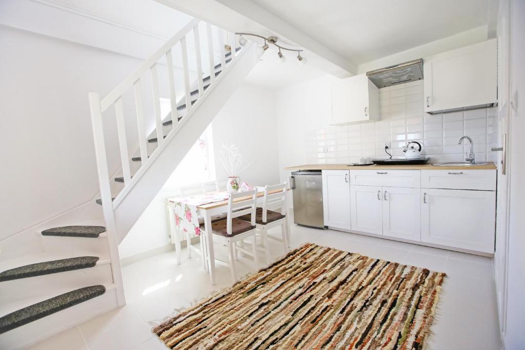 eine Küche mit weißen Schränken und einer weißen Treppe in der Unterkunft Apartamenty Pod Zamkową Górą in Rajgród